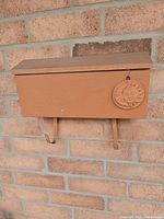Front view of painted mailbox mounted on brick wall