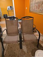 Front view of both patio chairs showing frames and mesh fabric