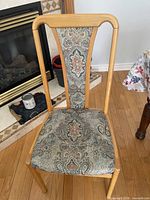 Front view of chair showing wood frame and paisley upholstery