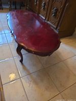 Full view of oval mahogany coffee table on tile floor