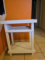 Front view of white wood three-tier table