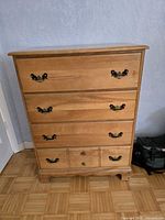 Front view of five-drawer wood dresser