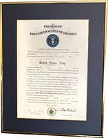 Full view of framed U.S. Navy commission certificate showing frame, mat, and document