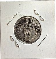 Obverse with standing haloed figure in robe inside cardboard flip