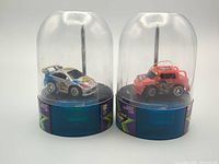 Front view of both micro RC cars in their dome cases