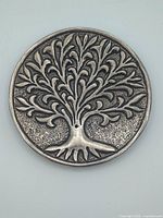Top view of round metal holder showing Tree of Life relief and center hole