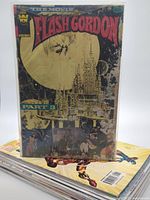 Stack of comic books with Flash Gordon The Movie Part 3 on top
