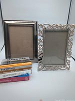 Front view of both metal picture frames and stack of five cassette tapes