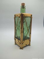 Full view of decanter showing glass bottle and brass frame