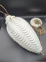 Full view of frosted glass shade with brass chain and canopy