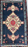 Full view of blue Ardabil rug showing overall design and fringe