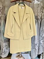 Front view of jacket over dress on hanger