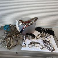 Overall view of plastic bin and assorted belts spread on tabletop