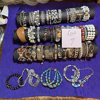 Full view of three display rods filled with assorted bracelets plus additional beaded pieces below