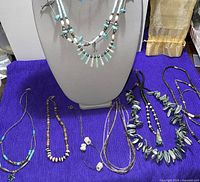 Overall lot showing necklaces on stand and table