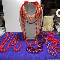 Group of necklaces displayed on bust and table