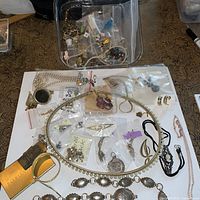 Overview of belts and bagged jewelry parts on table