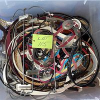 Bin filled with assorted belts showing variety of colors and materials
