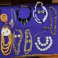 All thirteen jewellery pieces laid out on purple fabric