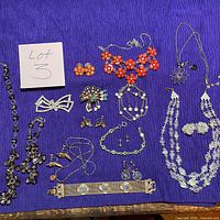 Overview of all 13 jewelry pieces on fabric background