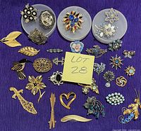 All brooches laid out on purple fabric showing variety
