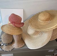 Group view of four straw hats showing variety