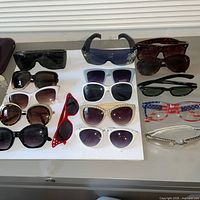 Group shot of all sunglasses and cases on tabletop