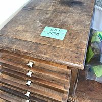 Top view of wooden cabinet showing surface wear and drawer fronts with porcelain knobs