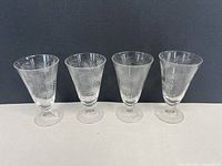 Four clear etched Fostoria Lido goblets side by side