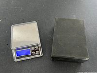 Scale with lid beside black box