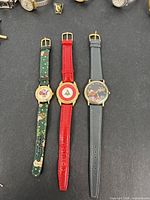 Three Christmas watches side by side showing straps and dials