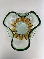 Top view showing freeform shape, amber interior, green rim of heavy glass bowl