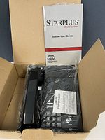 Box opened showing wrapped phone, handset and user guide