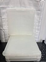 Stack of four clear scrapbook cases with top one opened upright