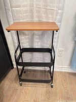 Full view of cart front showing wood top and two mesh baskets on casters