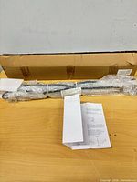 Wrapped metal stand components next to box and instructions