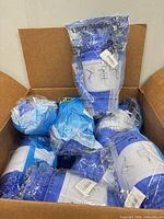 Open box showing multiple sealed blue/white manual water pumps