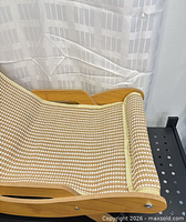 Left side view of curved wood frame and woven seat