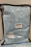 Front view of light blue packaged duvet set with label visible