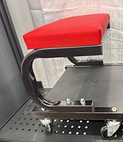 Overall view showing red padded seat and black metal frame