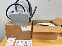 Two boxed Kay SolidSense sanitizer dispensers with hoses, accessories and manuals