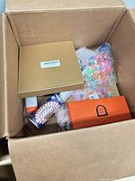 Top view of box showing gold box, floral cylinder, UNO box, bag of colourful charms