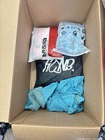 Overview of box showing packaged garments and loose turquoise item