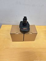 Two cardboard boxes with one DM20DC12 adapter placed on top