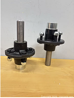 Two hub and spindle assemblies side by side on tabletop