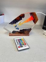 Full view of Vegeta Final Flash LED lamp on wood base with remote