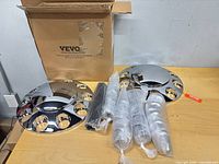 Boxed Vevor hub caps with wrapped bolt covers on table