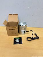 Fan, box and manual on table