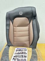 Front view of seat cover showing colour, stitching, and headrest logo