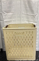 Assembled beige plastic foldable laundry basket front view